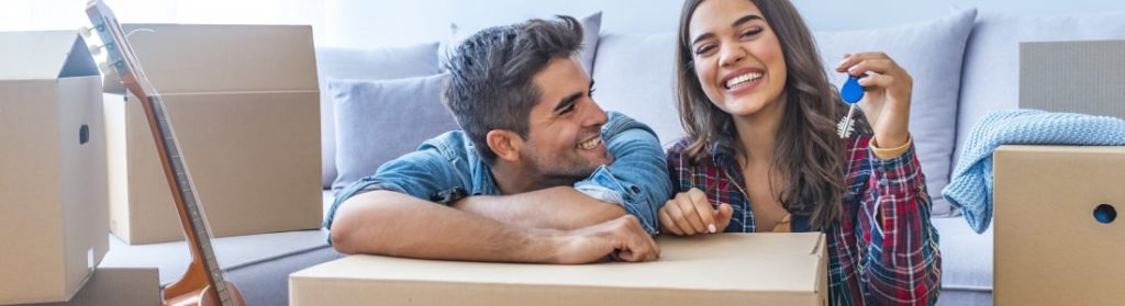 Couple laughing while surrounded by moving boxes