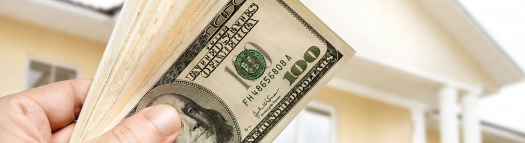 person's hand holding cash
